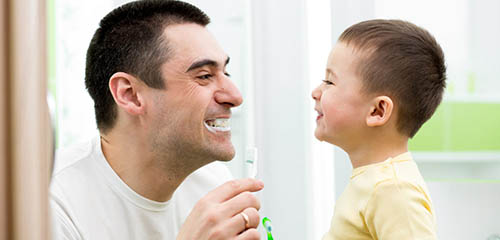 Father and Son Smile After Brushing Their Teeth